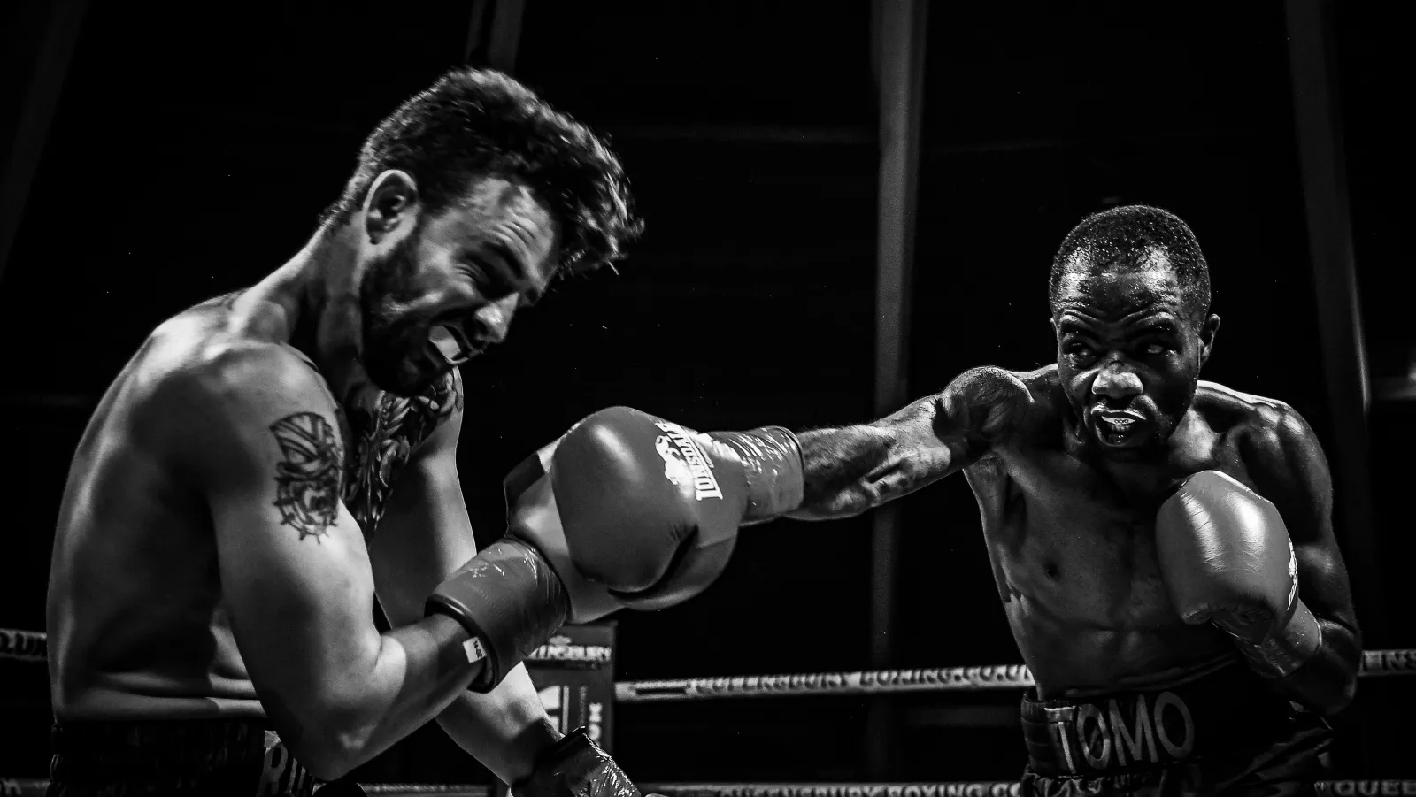 Two boxers mid-exchange, right hand landing, black and white