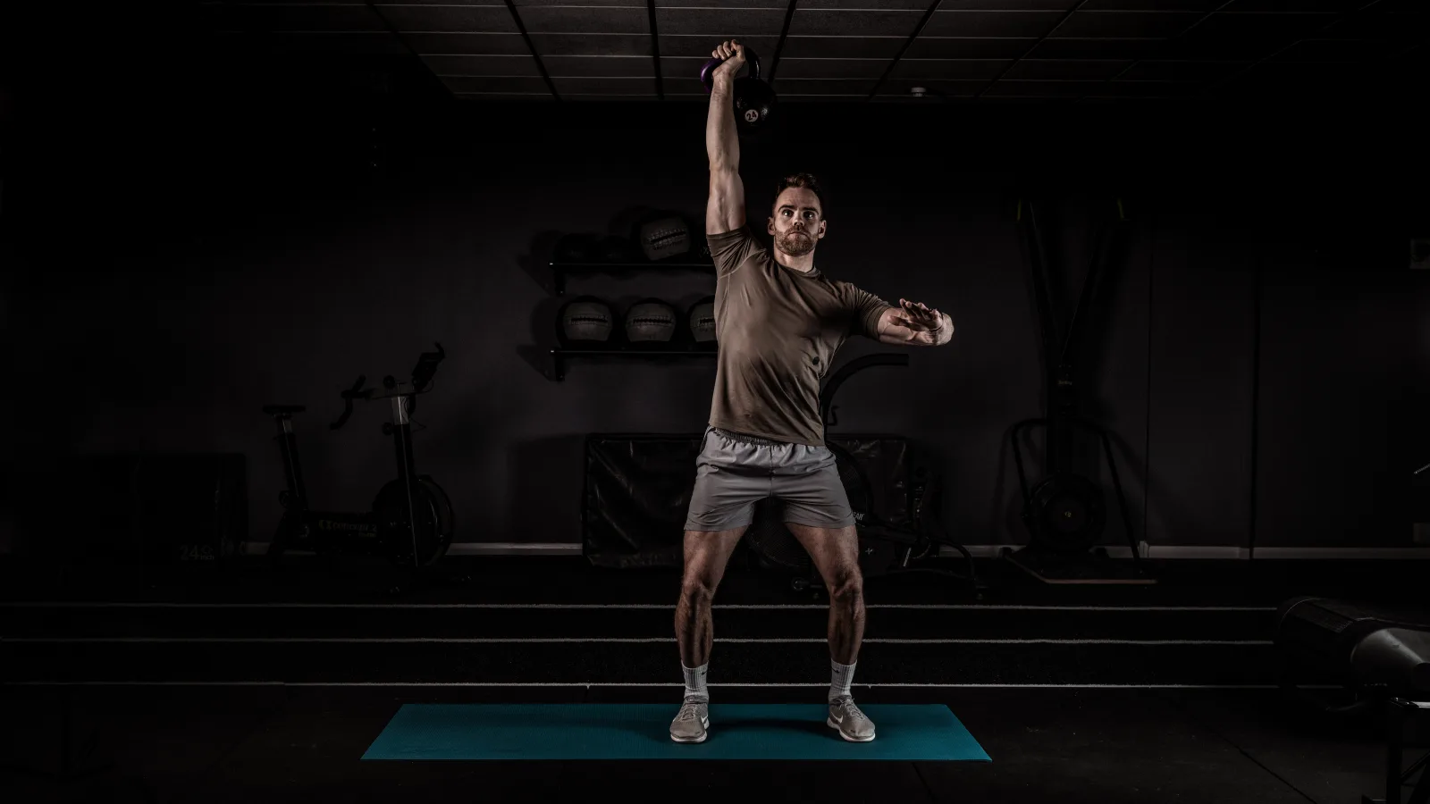 Athlete mid-movement in low-key gym lighting, Conquer campaign