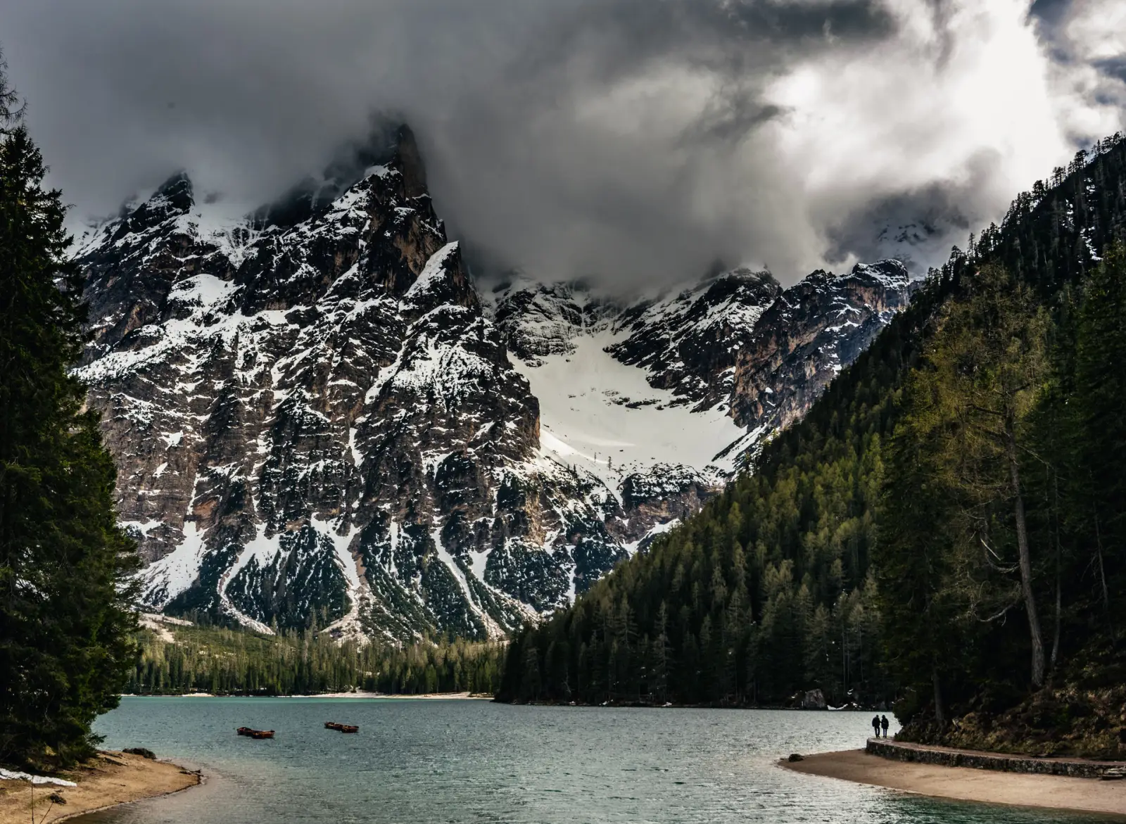 Alpine lake below a snow-covered peak, Lago di Braies